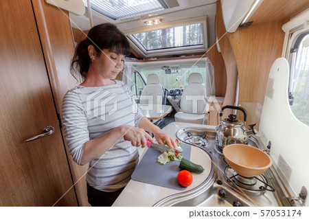 Woman cooking in camper, motorhome interior Woman cooking in camper, motorhome interior 57053174