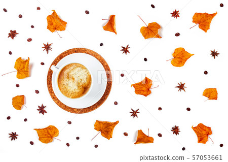 White Cup of coffee surrounded by leaves and star anise. 57053661