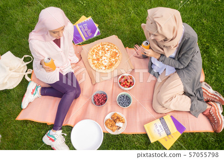 Top view of busy students eating pizza and drinking fizzy drink 57055798