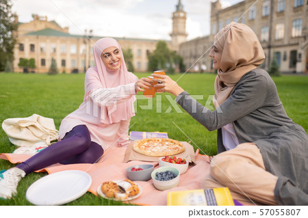 Cheerful muslim students enjoying pizza time outside Cheerful muslim students enjoying pizza time outside 57055807