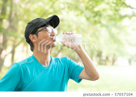 從塑料瓶的日本中年人飲用水 57057104