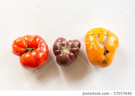 Ugly organic colorful tomatoes set on white. 57057640