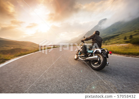 Motorcycle driver riding in Dolomite pass, Italy, Europe. 57058432