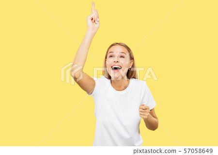 Caucasian young woman's half-length portrait on yellow background Caucasian young woman's half-length portrait on yellow background 57058649