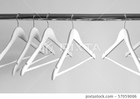 Empty clothes hangers on metal rail against grey 57059086