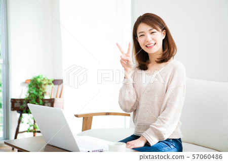使用個人計算機的一個少婦在屋子裡 57060486