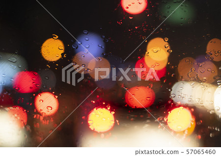 Close up windshield raindrop heavy rain with bokeh of traffic light ,Driving car on the road in Close up windshield raindrop heavy rain with bokeh of traffic light ,Driving car on the road in 57065460