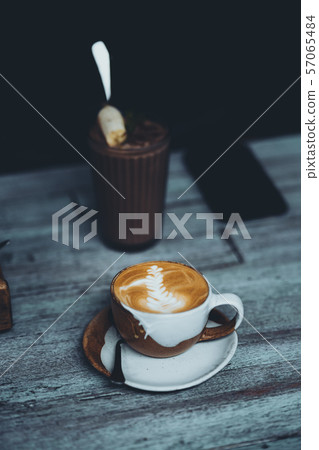 Hot latte coffee in a cup On a wooden table in a coffee shop Hot latte coffee in a cup On a wooden table in a coffee shop 57065484