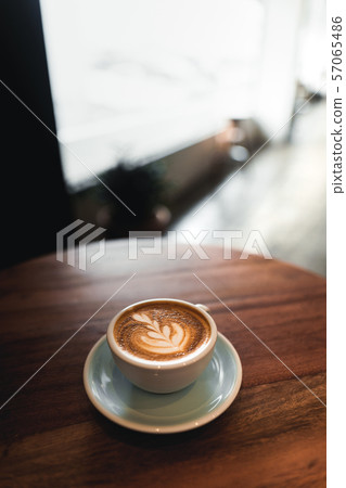 Hot latte coffee in a cup On a wooden table in a coffee shop Hot latte coffee in a cup On a wooden table in a coffee shop 57065486