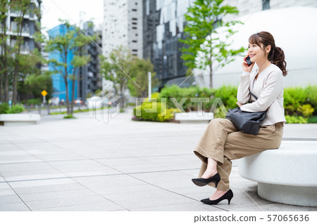 A woman talking on a smartphone A woman talking on a smartphone 57065636