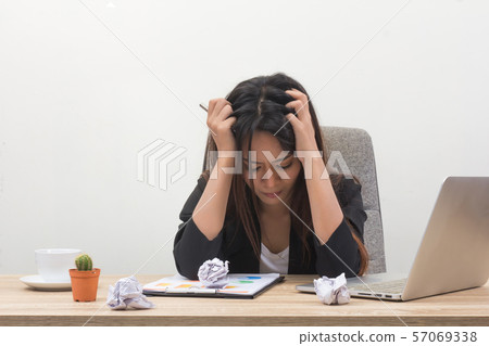 Woman feeling stress from work. Young and beautiful businesswoman with laptop computer tired in office. Exhausted female worker having a headache. Nervous lady pulling her hair out. Woman feeling stress from work. Young and beautiful businesswoman with laptop computer tired in office. Exhausted female worker having a headache. Nervous lady pulling her hair out. 57069338