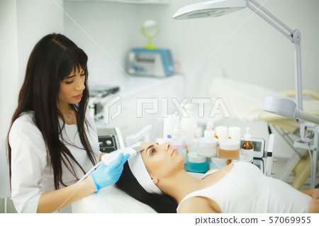 Rejuvenating facial treatment. Model getting lifting therapy massage in a beauty SPA salon Rejuvenating facial treatment. Model getting lifting therapy massage in a beauty SPA salon 57069955