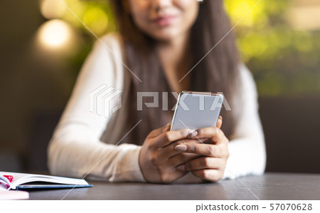 Student girl holding brand new smartphone, texting friends 57070628