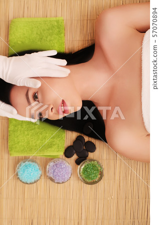 Spa therapy for young woman having facial mask at beauty salon - indoors 57070894