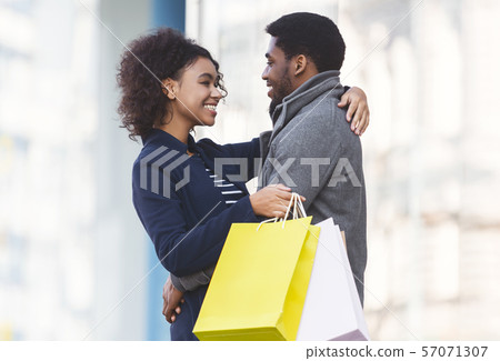 Black couple cuddling in the street after shopping Black couple cuddling in the street after shopping 57071307