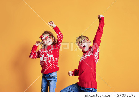 Children in warm red Christmas sweaters 57072173