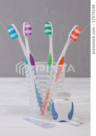 Toothbrush in glass, dental floss and chewing gums. 57074286