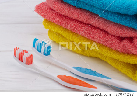 Two toothbrush and stack of colorful towels. Two toothbrush and stack of colorful towels. 57074288