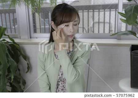 Young woman doing makeup with a rolling pin 57075962