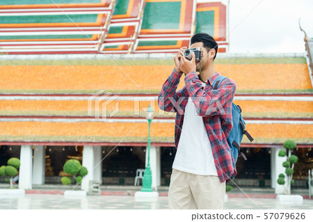 Asian man tourist walk taking photo with film camera  at Wat Suthat 57079626