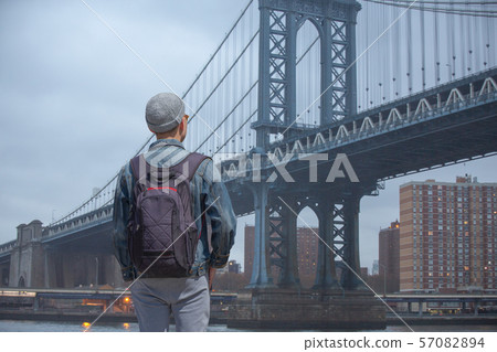 man walks on the background of the brooklyn bridge 57082894
