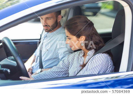 Dark-haired wife wearing striped blouse driving car 57084369