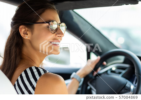 Woman driving her car and looking into right side mirror 57084869