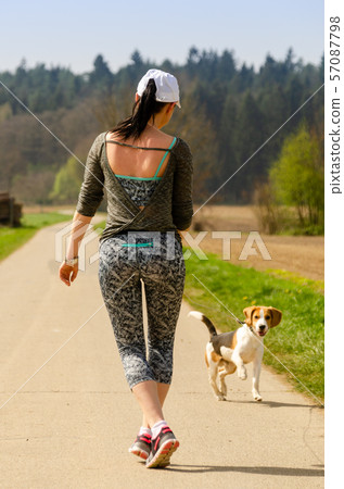Girl running with Beagle dog outdoors in nature. Girl running with Beagle dog outdoors in nature. 57087798