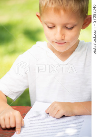 boy in T-shirt is reading, back to school concept. boy in T-shirt is reading, back to school concept. 57088340