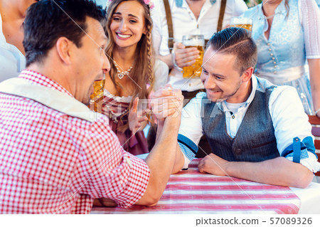 Bavarian friends practicing the high art of arm wrestling 57089326