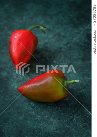 Red peppers lie on gray concrete Red peppers lie on gray concrete 57089788