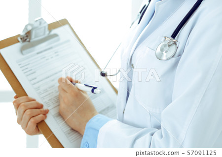 Female doctor using medical form on clipboard closeup. Physicianat work in hospital or clinic Female doctor using medical form on clipboard closeup. Physicianat work in hospital or clinic 57091125