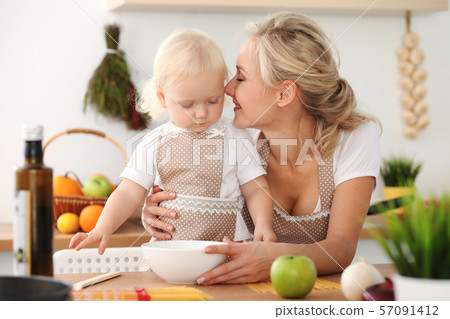 Happy mother and little daughter cooking in kitchen. Spending time all together, family fun concept 57091412