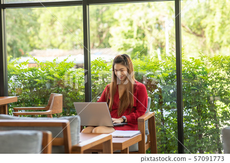Beautiful Attractive Asian woman wearing red dress working with computer laptop and thinking to get ideas and requirement in Business startup feeling so happiness,Business Startup Concept 57091773