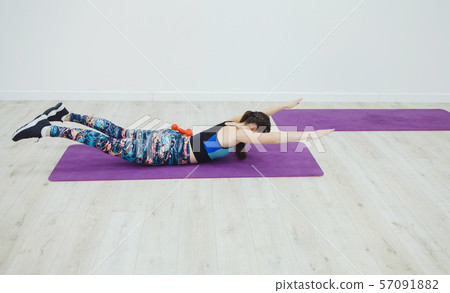 Sporting woman practicing the cobra pose 57091882