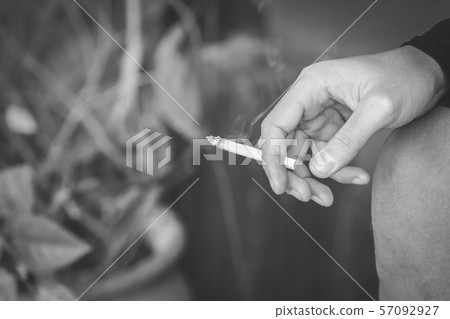 Close up male in hand holding a cigarette. 57092927