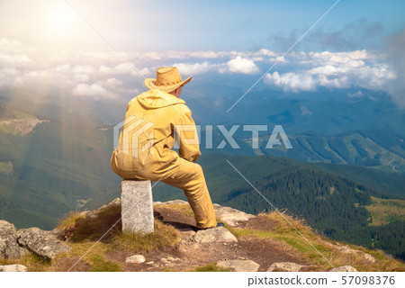 Man on top mountain looking into the distance Man on top mountain looking into the distance 57098376