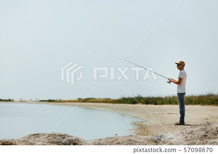 Young man fishing at sea Young man fishing at sea 57098670