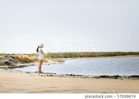 young woman walks along the seashore young woman walks along the seashore 57098674