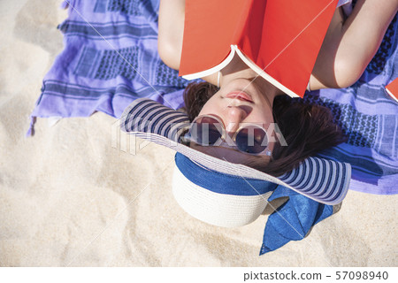 Closeup of pretty woman lying and reading a book 57098940