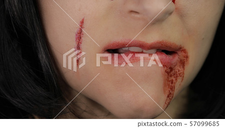 Vampire Halloween woman portrait. Vampire girl with dripping blood near her lips 57099685