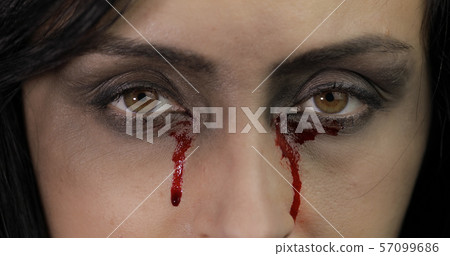 Vampire Halloween woman portrait. Vampire girl with dripping blood near eyes Vampire Halloween woman portrait. Vampire girl with dripping blood near eyes 57099686