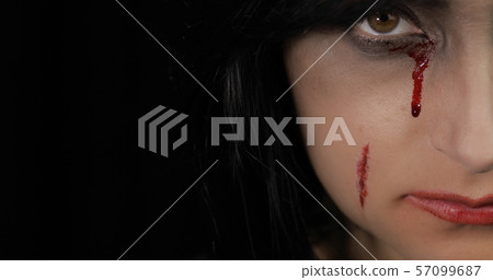 Vampire Halloween woman portrait. Vampire girl with dripping blood near eyes 57099687