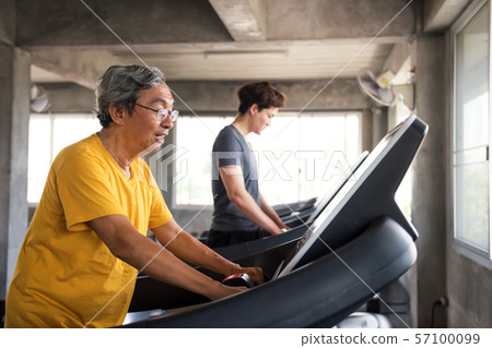 Senior and young men exercise in gym 57100099