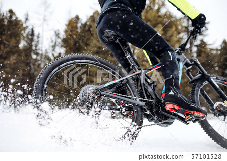 Midsection of mountain biker riding in snow outdoors in winter. 57101528