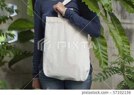 Girl is holding bag canvas fabric for mockup blank 57102136