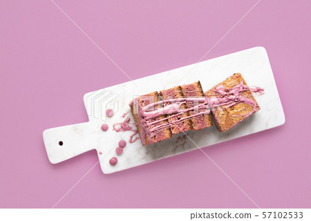 Pink brownie slices on marble cutting board Pink brownie slices on marble cutting board 57102533