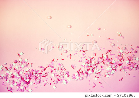 Colorful sprinkles on a pink background, top view with copy space 57102963