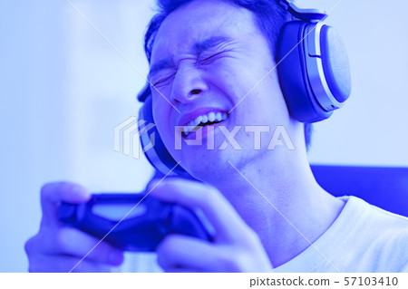 Image of e-sports: Scenes where young people are excited to play games with a controller in one hand Image of e-sports: Scenes where young people are excited to play games with a controller in one hand 57103410