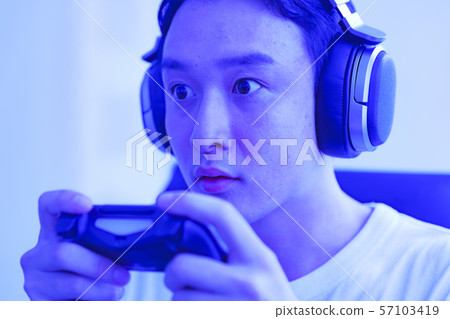 電子競技的形象：年輕人興奮地用控制器一手玩遊戲的場景 57103419